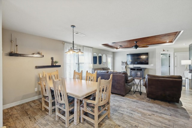 1308 Cochise Trl, Granbury, TX 76048 - dining area featuring a raised ceiling, visible vents, a glass covered fireplace, light wood-style flooring, and ceiling fan