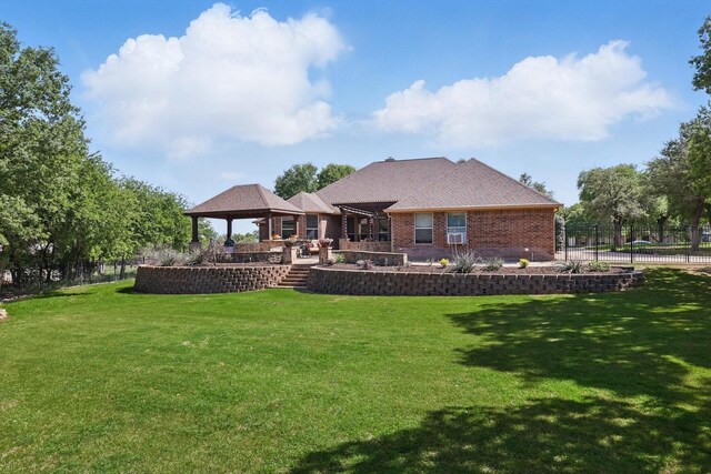 back of house with a lawn, fence, a gazebo, and brick siding