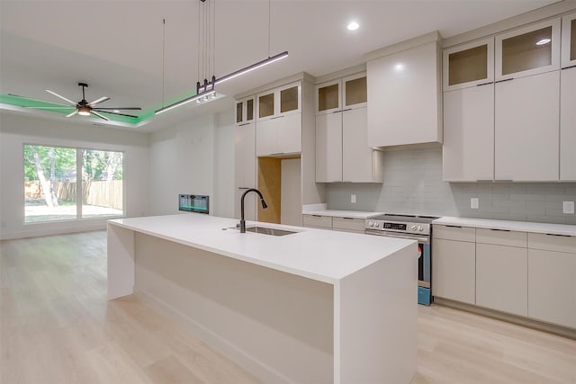 2229 Varsity Dr, Grand Prairie, TX 75051 - kitchen featuring a sink, decorative backsplash, stainless steel range with electric cooktop, light wood-style flooring, and white cabinets