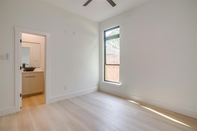 2229 Varsity Dr, Grand Prairie, TX 75051 - spare room featuring baseboards, a ceiling fan, a sink, and light wood-style flooring
