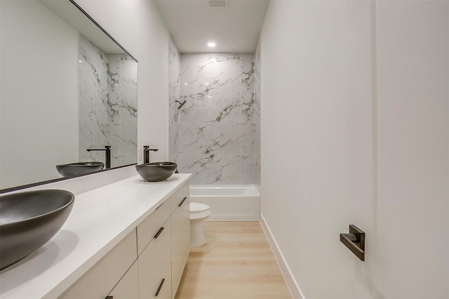 2229 Varsity Dr, Grand Prairie, TX 75051 - full bathroom featuring double vanity, toilet, wood finished floors, and a sink