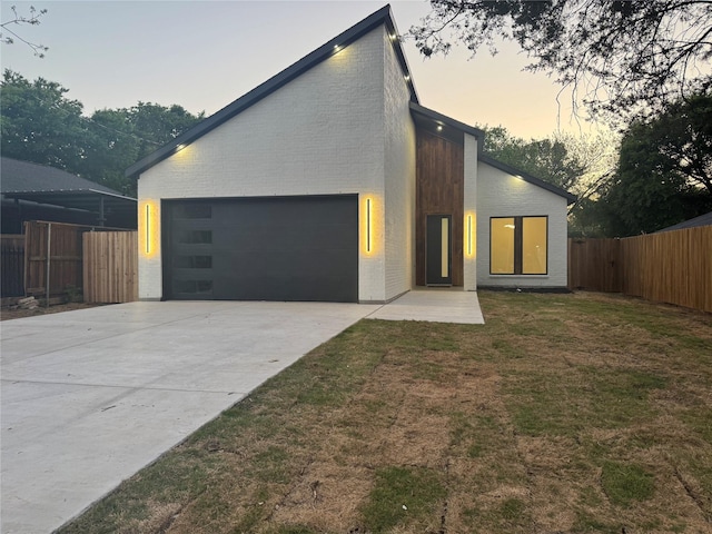 2229 Varsity Dr, Grand Prairie, TX 75051 - contemporary house featuring concrete driveway, an attached garage, fence, a yard, and brick siding