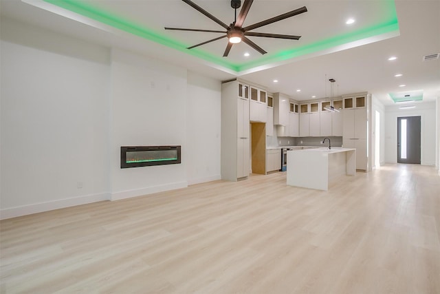 2229 Varsity Dr, Grand Prairie, TX 75051 - unfurnished living room featuring light wood finished floors, a sink, a glass covered fireplace, heating unit, and a ceiling fan