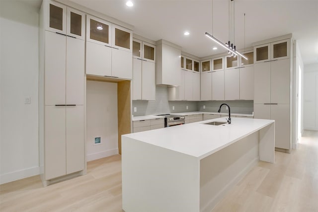 2229 Varsity Dr, Grand Prairie, TX 75051 - kitchen featuring decorative backsplash, stainless steel range with electric stovetop, a sink, and light wood-style floors