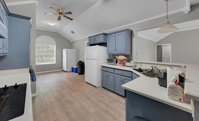 2618 S 2nd St, Waco, TX 76706 - kitchen featuring blue cabinets, vaulted ceiling, a sink, and freestanding refrigerator