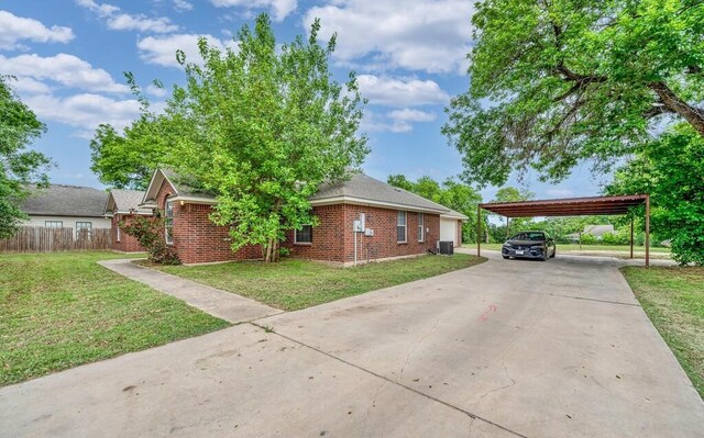 2618 S 2nd St, Waco, TX 76706 - view of home's exterior featuring a carport, a lawn, driveway, and brick siding