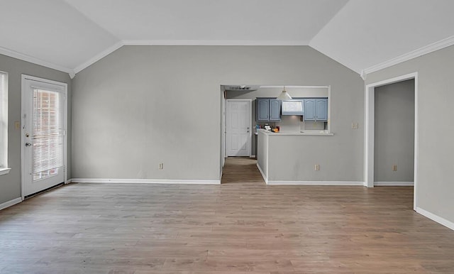 2618 S 2nd St, Waco, TX 76706 - unfurnished living room featuring vaulted ceiling, ornamental molding, light wood-style floors, and baseboards