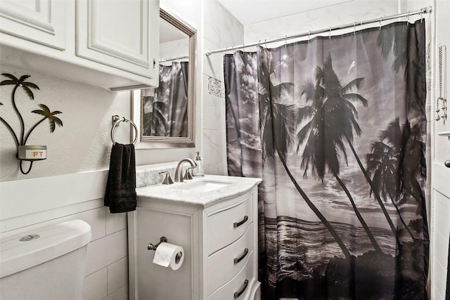 full bathroom with curtained shower, toilet, and vanity
