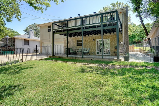 rear view of property with a fenced backyard, a wooden deck, a lawn, board and batten siding, and a patio