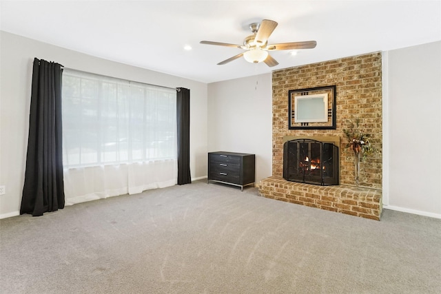 unfurnished living room featuring carpet floors, baseboards, a fireplace, and ceiling fan