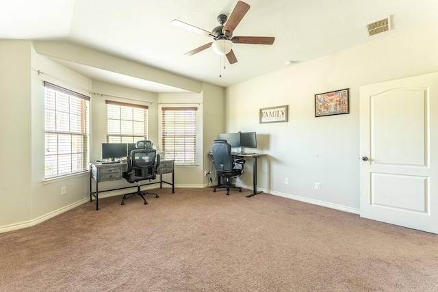 carpeted home office with baseboards, a ceiling fan, and visible vents