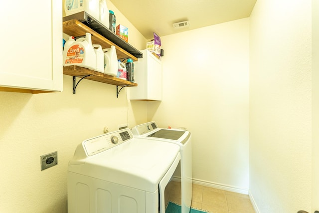 laundry room with light tile patterned floors, cabinet space, baseboards, visible vents, and independent washer and dryer