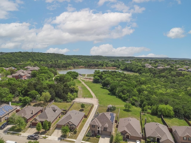 bird's eye view featuring a wooded view, a residential view, and a water view