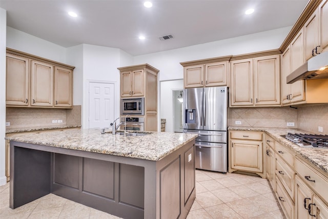 kitchen featuring visible vents, light stone countertops, under cabinet range hood, an island with sink, and appliances with stainless steel finishes