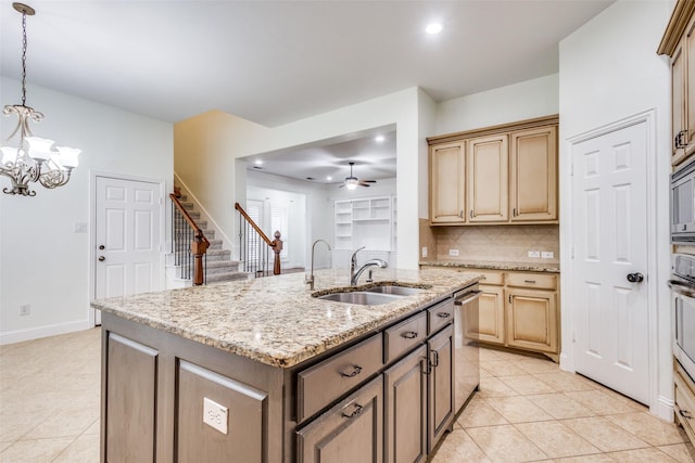 kitchen featuring light tile patterned floors, a sink, a kitchen island with sink, and ceiling fan with notable chandelier