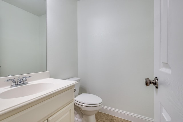 bathroom featuring baseboards, vanity, tile patterned flooring, and toilet