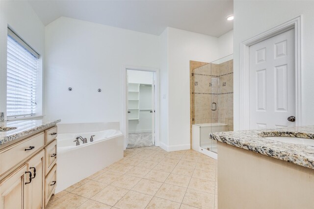 full bath with tile patterned floors, a stall shower, a spacious closet, a garden tub, and vanity