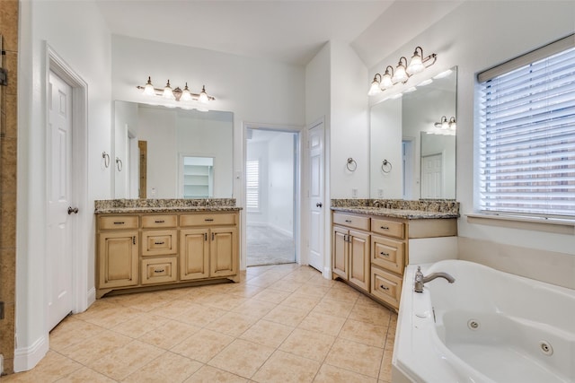 bathroom featuring plenty of natural light, baseboards, tile patterned flooring, and a tub with jets