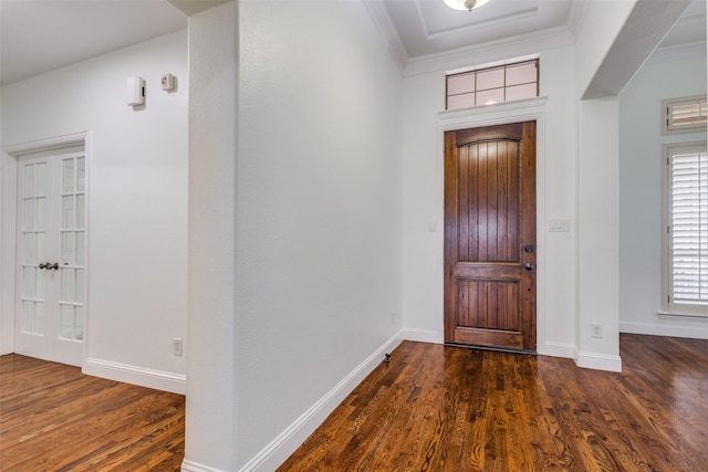 foyer entrance featuring baseboards, crown molding, and dark wood-style floors