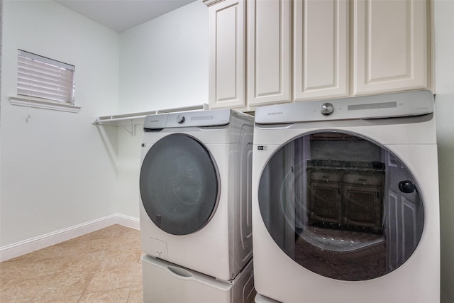 laundry area featuring baseboards, cabinet space, and washer and clothes dryer