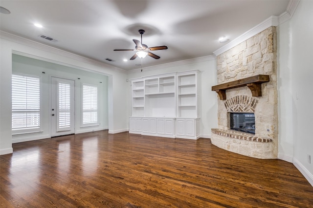 unfurnished living room featuring ceiling fan, a stone fireplace, crown molding, baseboards, and dark wood-style flooring