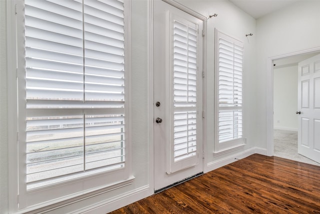 doorway to outside with dark wood finished floors and a wealth of natural light