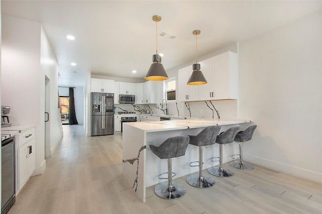 kitchen with plenty of natural light, appliances with stainless steel finishes, and light wood-style flooring
