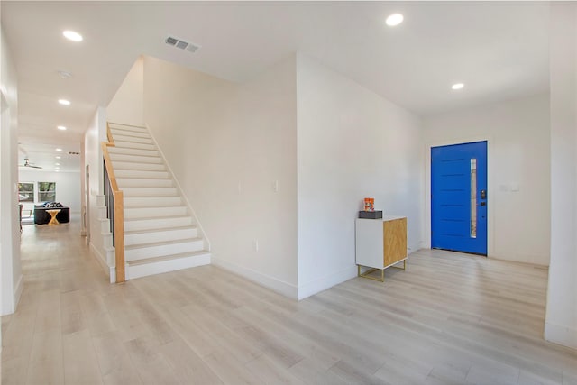 foyer featuring recessed lighting, light wood-style floors, stairway, and baseboards