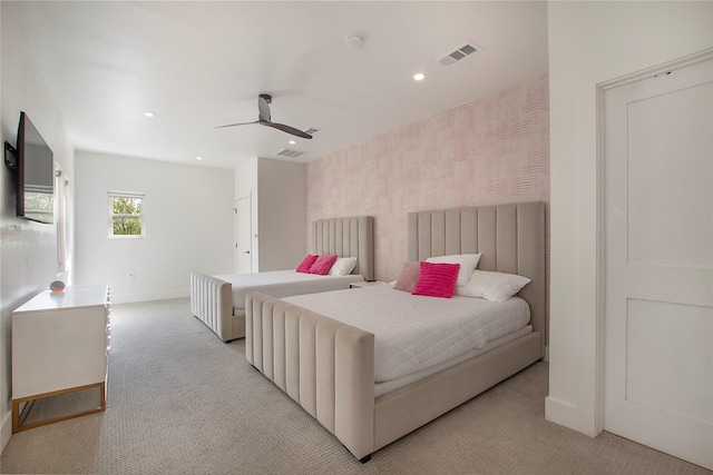 bedroom featuring wallpapered walls, baseboards, visible vents, and light colored carpet