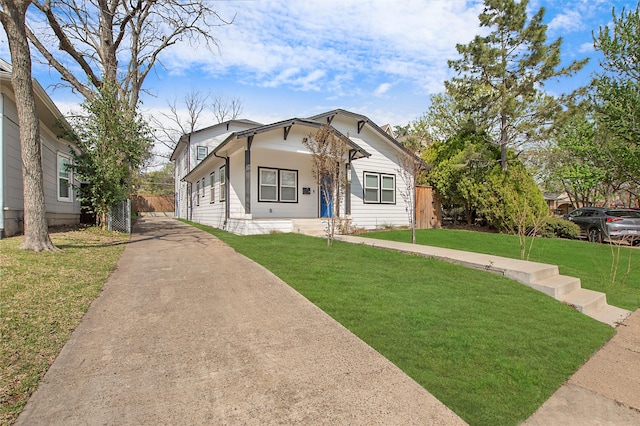 bungalow-style house with fence, driveway, and a front lawn