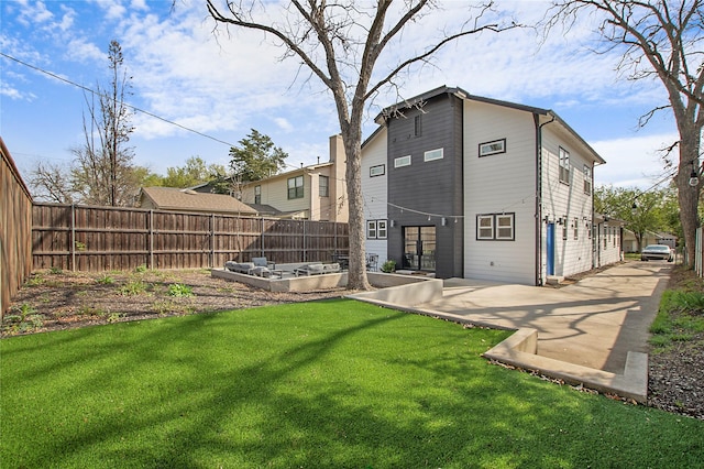 rear view of house featuring a patio area, a fenced backyard, and a yard