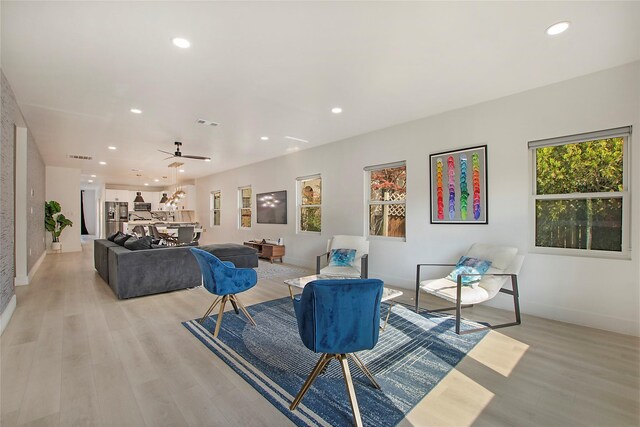 living room with baseboards, recessed lighting, and light wood-style floors
