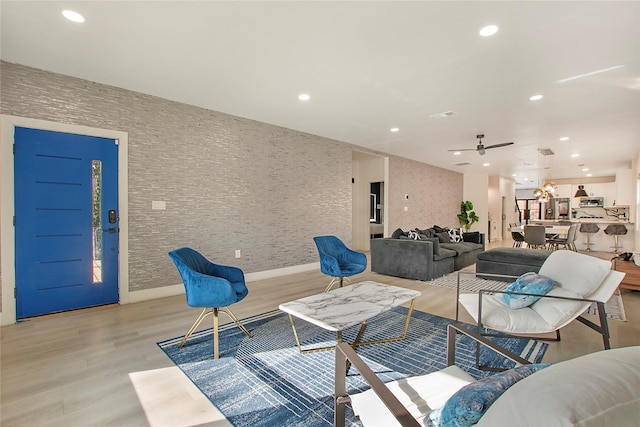 living room with light wood-type flooring, baseboards, and recessed lighting