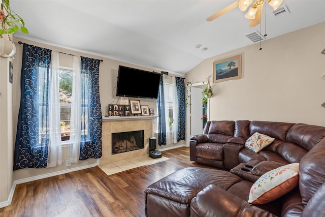living area with wood finished floors, visible vents, vaulted ceiling, and ceiling fan