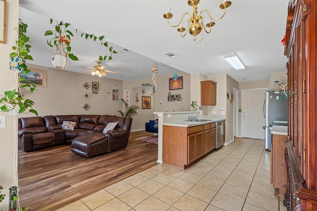 kitchen with a sink, open floor plan, light countertops, appliances with stainless steel finishes, and visible vents