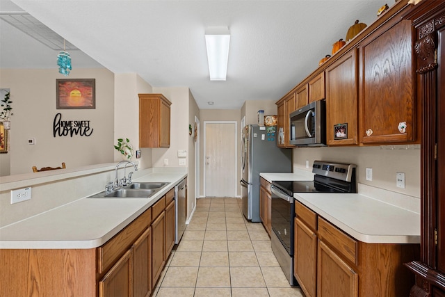 kitchen featuring appliances with stainless steel finishes, a sink, light tile patterned flooring, and light countertops