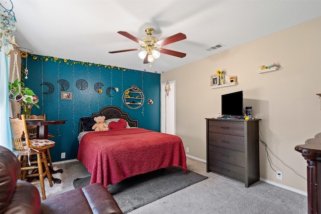 carpeted bedroom with visible vents, a ceiling fan, and baseboards