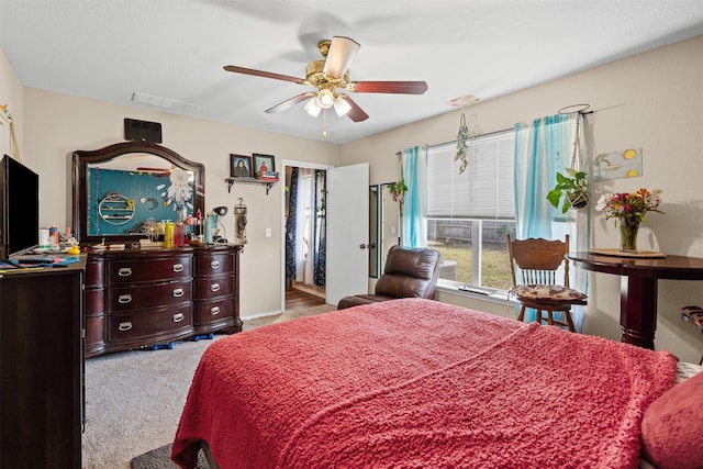 carpeted bedroom featuring a ceiling fan and visible vents