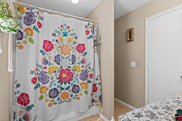 bathroom with shower / bath combo with shower curtain and tile patterned floors
