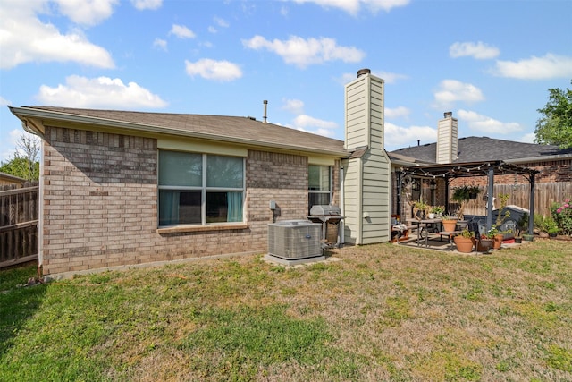 rear view of house featuring a patio area, a lawn, central AC, and fence