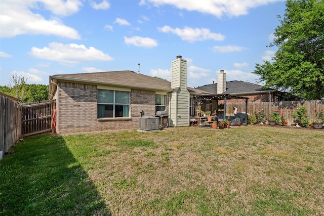 back of house featuring a lawn, a fenced backyard, brick siding, and central AC unit