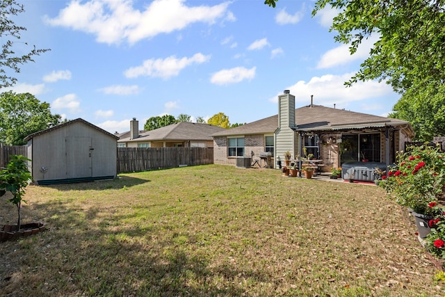 view of yard featuring a storage unit, central air condition unit, an outbuilding, and a fenced backyard