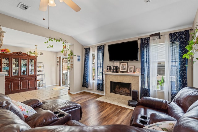 living area featuring vaulted ceiling, a ceiling fan, visible vents, and plenty of natural light