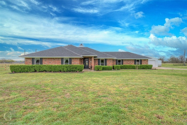 ranch-style home featuring brick siding, a front yard, and a garage