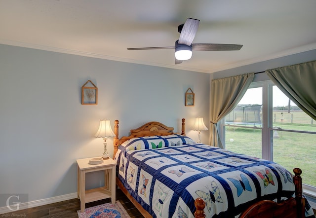 bedroom with baseboards, wood finished floors, ornamental molding, and ceiling fan