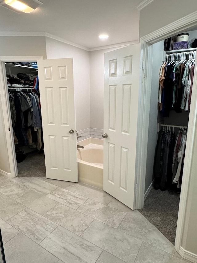 bathroom with baseboards, a garden tub, crown molding, and recessed lighting