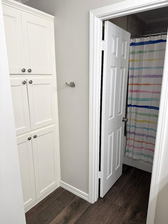 full bath with a shower with curtain, baseboards, and wood finished floors