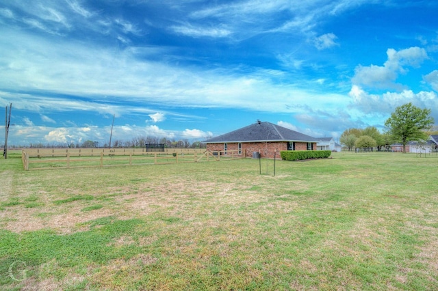 view of yard with a rural view and fence