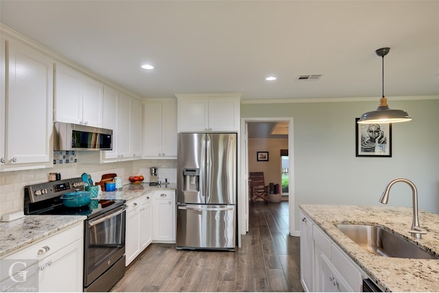 kitchen with a sink, decorative backsplash, ornamental molding, stainless steel appliances, and dark wood-style flooring