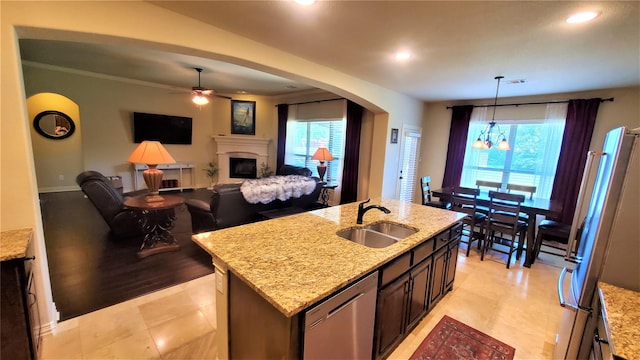 kitchen featuring visible vents, a sink, a fireplace, hanging light fixtures, and appliances with stainless steel finishes